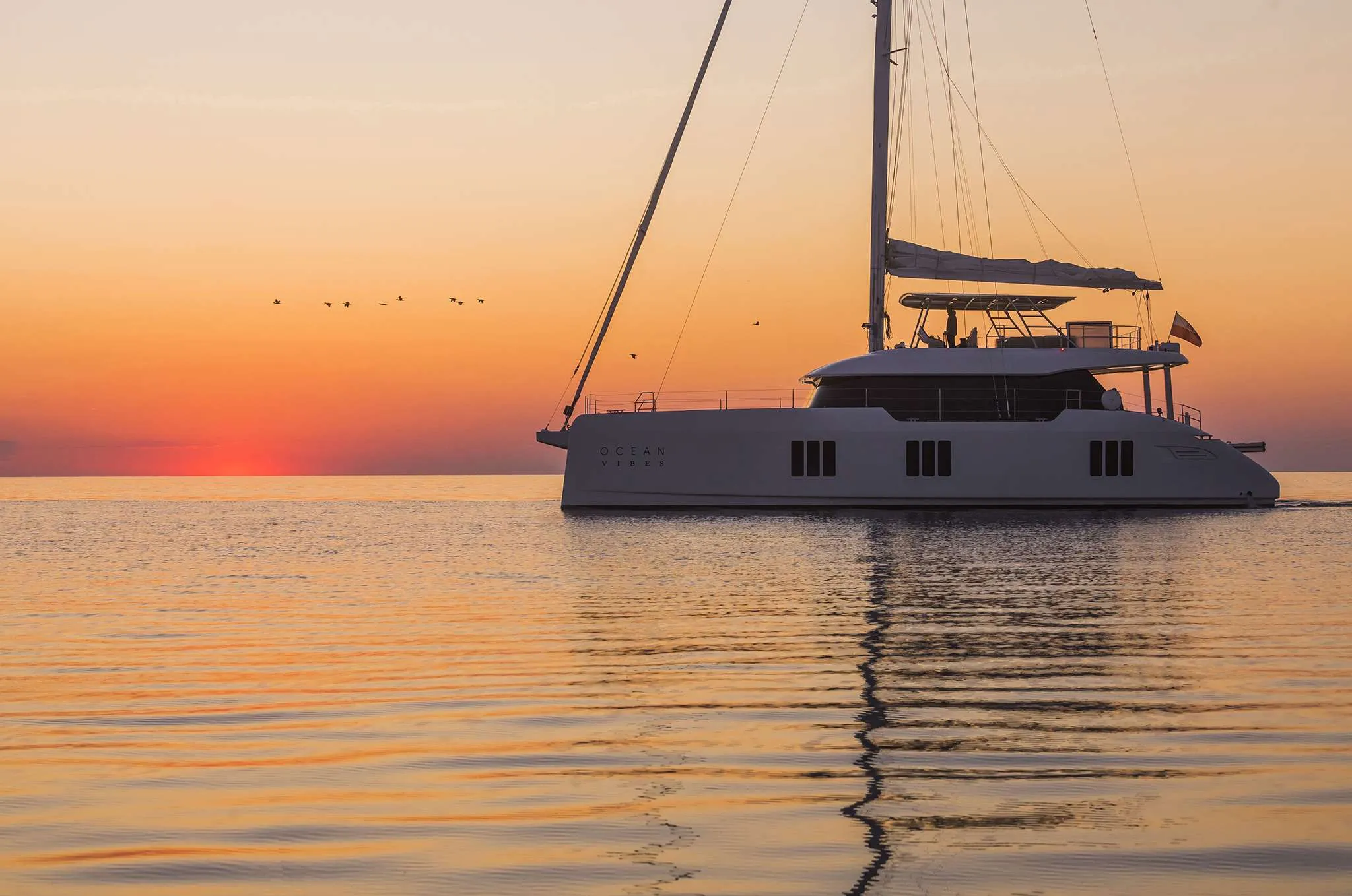 A Sunreef 70 sailing catamaran at anchor at sunset